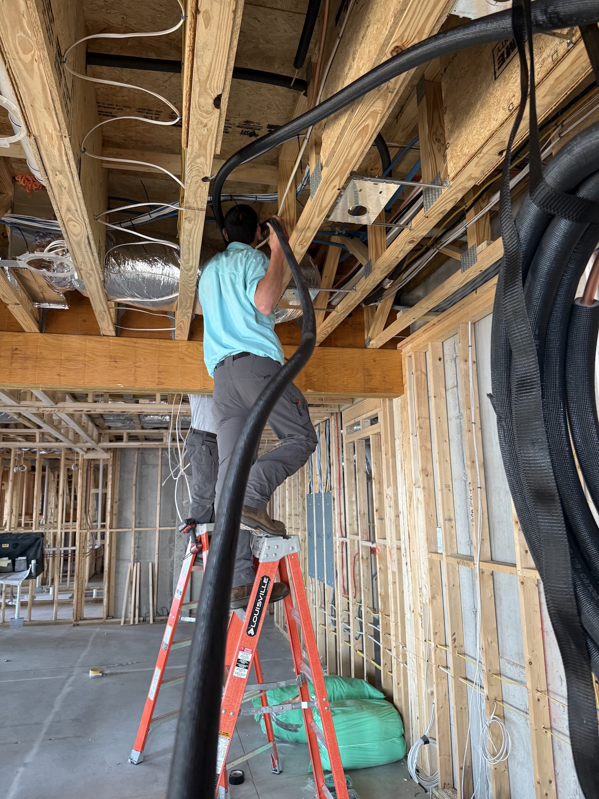 Cameron running a lineset for new construction HVAC