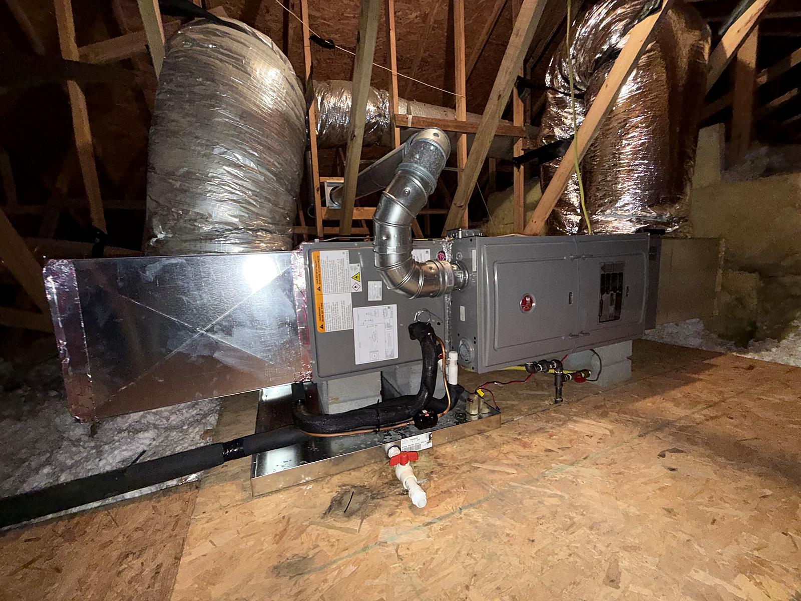 New Rheem gas furnace installed horizontally in an attic with custom plenum and venting