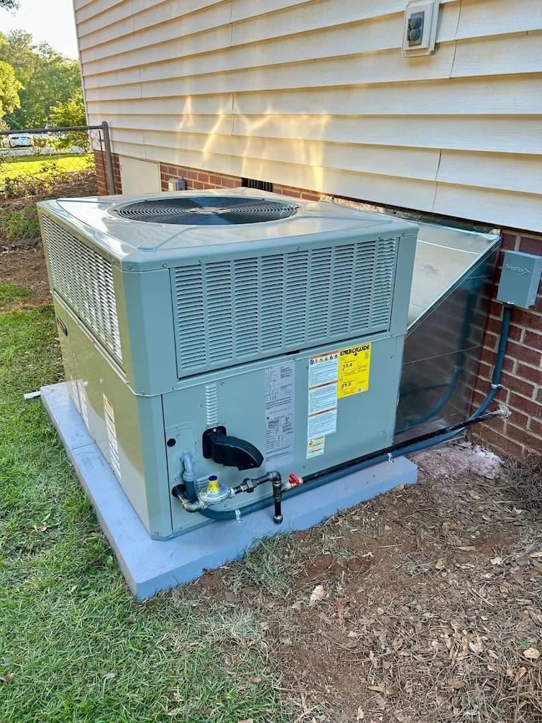 New gas package unit installed on a concrete pad beside a brick home in Upstate South Carolina