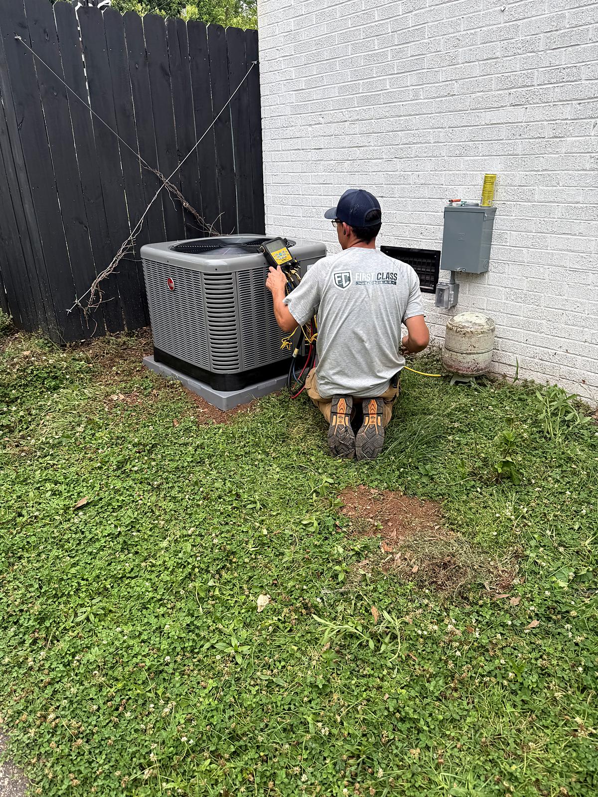 First Class technician commissioning a new Rheem AC unit with refrigerant gauges