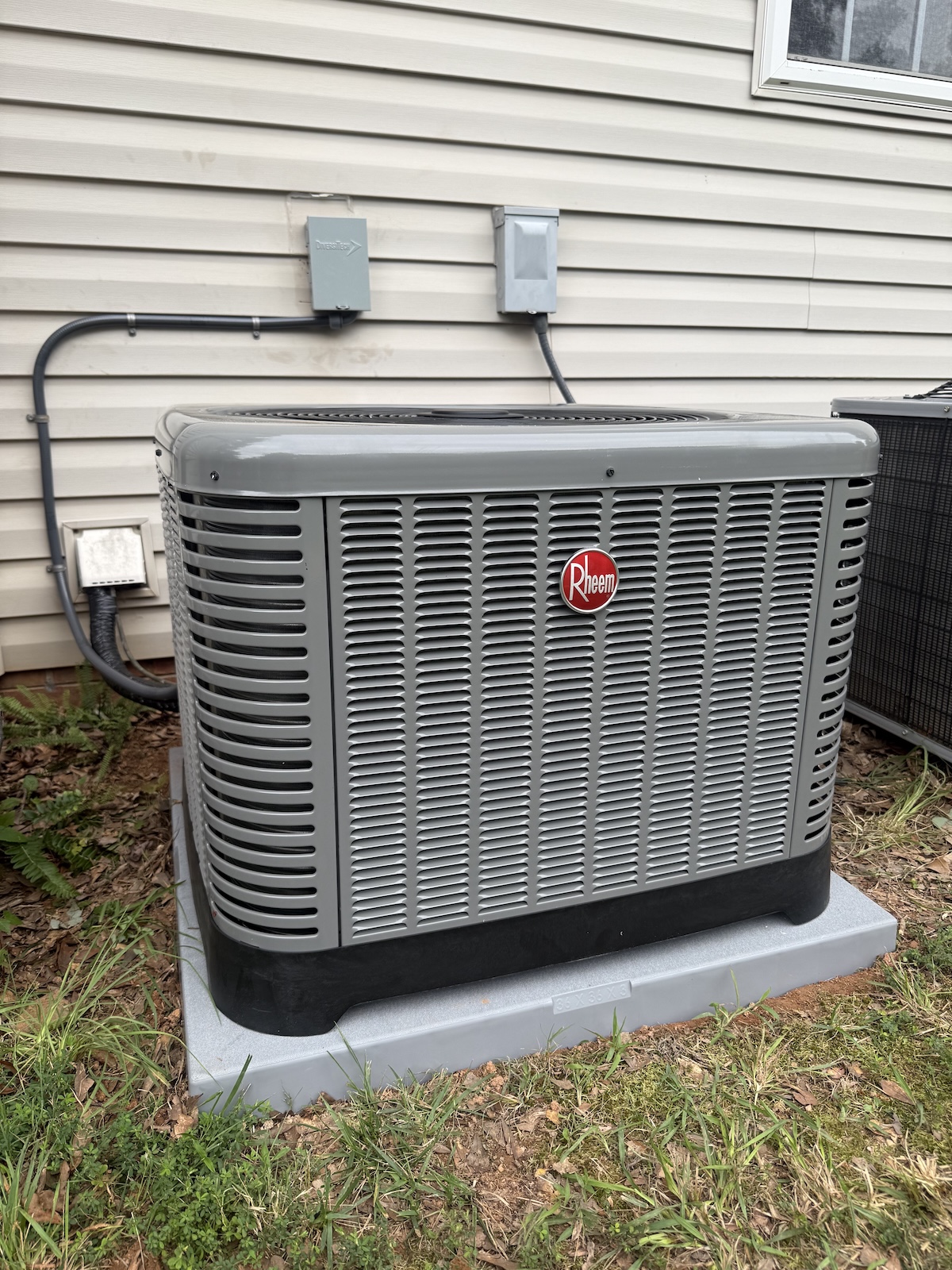 Rheem heat pump condenser installed on proper pad