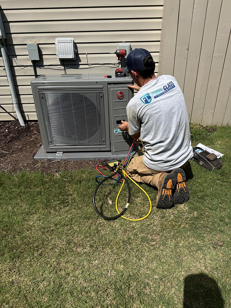 First Class Heating & Air technician installing a Rheem variable speed heat pump in Simpsonville, SC